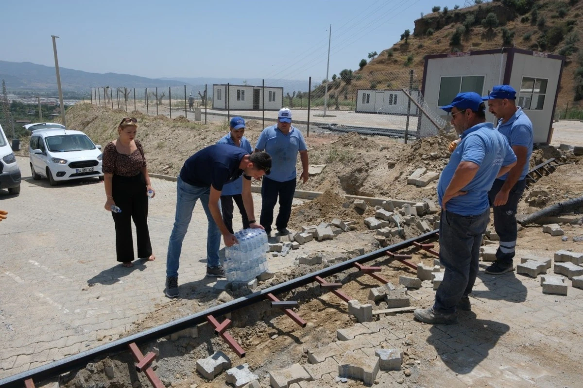 Sahada çalışan belediye işçileri buz gibi suyla serinledi