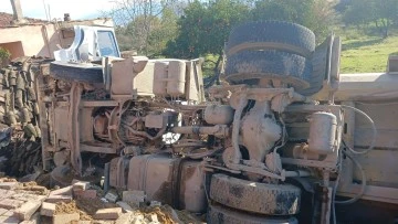Otob&uuml;se &ccedil;arpan kum y&uuml;kl&uuml; kamyon, bir evin &nbsp;bah&ccedil;esine devrildi