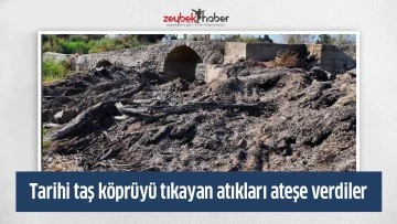 Tarihi taş k&ouml;pr&uuml;y&uuml; tıkayan atıkları ateşe verdiler